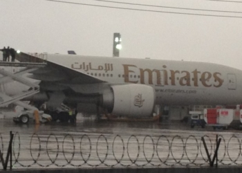 Funcionários da Emirates verificam o problema na asa atingida (Foto: Gabriel Barreira G1)