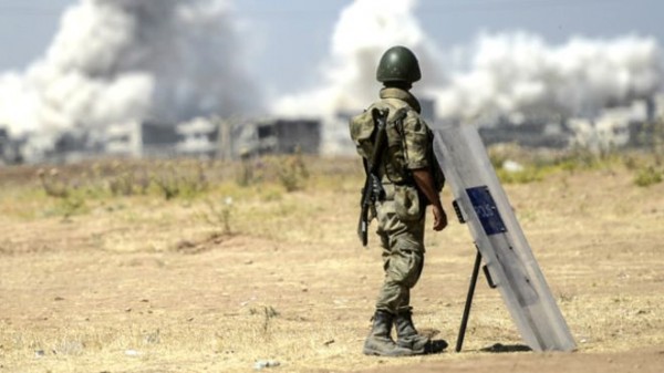Soldado turco observa desde Suruc, em território turco, os combates do outro lado da fronteira