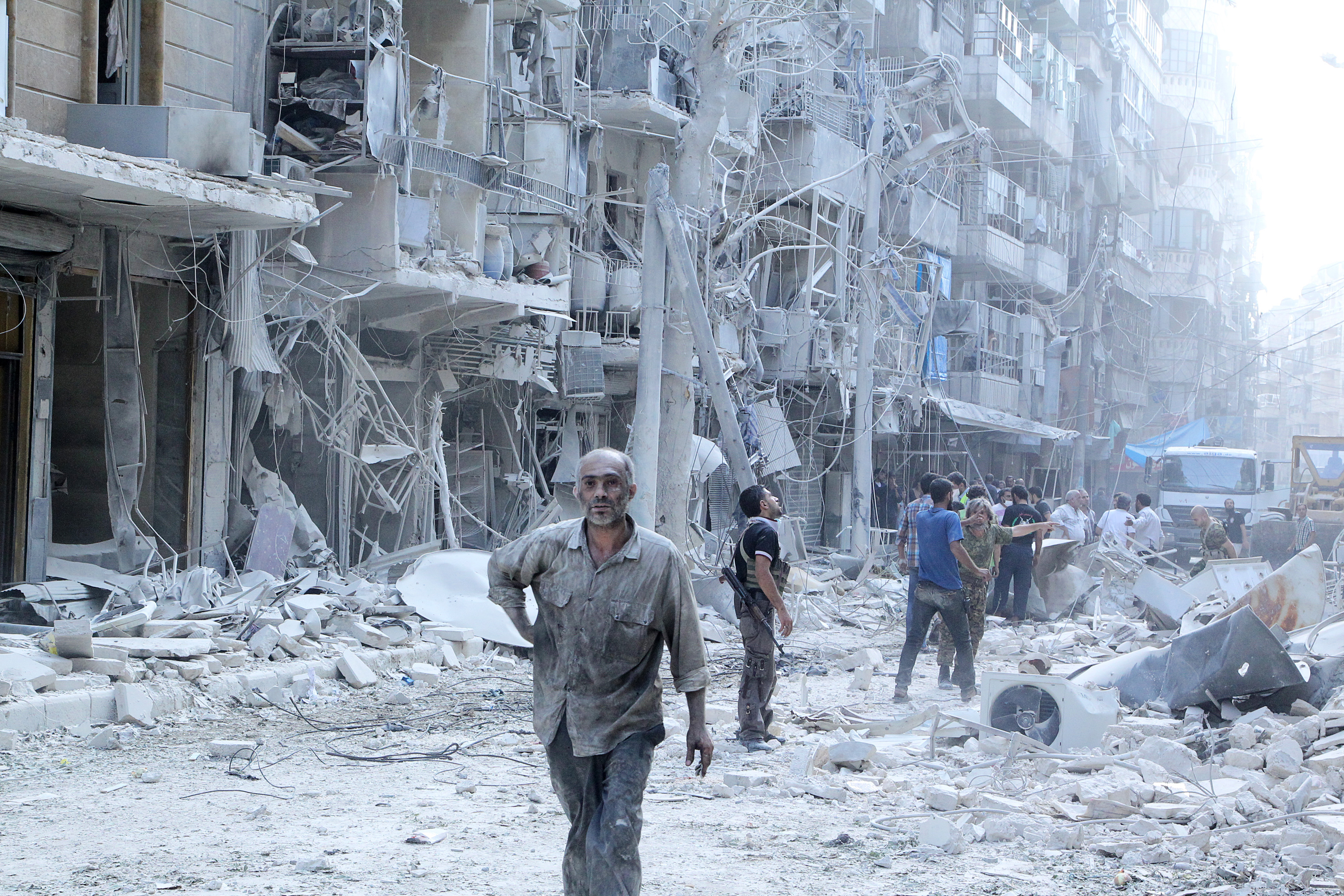 Residents look for survivors at a damaged site after what activists said was a barrel bomb dropped by forces loyal to Syria's President Bashar al-Assad in the Al-Shaar neighbourhood of Aleppo, Syria September 17, 2015. REUTERS/Abdalrhman Ismail - RTX242XG